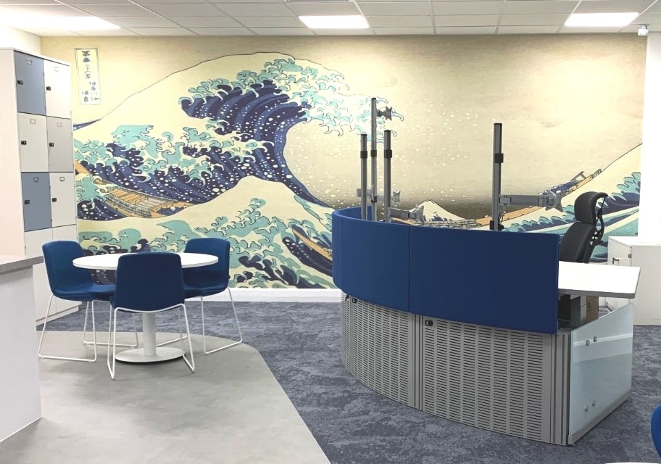 Reception desk white table and chairs with a wall featuring a sea waves design 